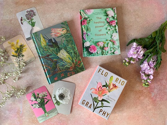 Flower-themed books spread out on a pink background