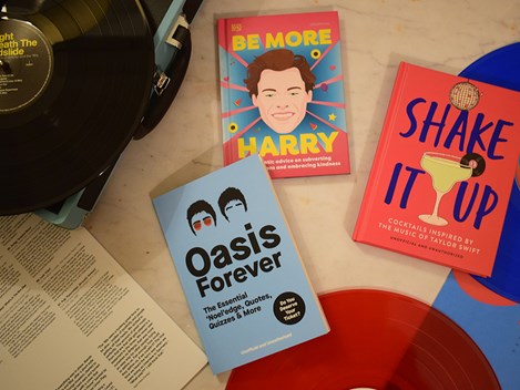 Music books scattered on a surface surrounded by records.