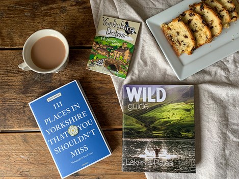 Books about Yorkshire on a table with tea and cake.