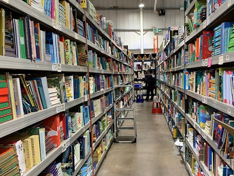 Warehouse interior featuring rows of books on shelving.